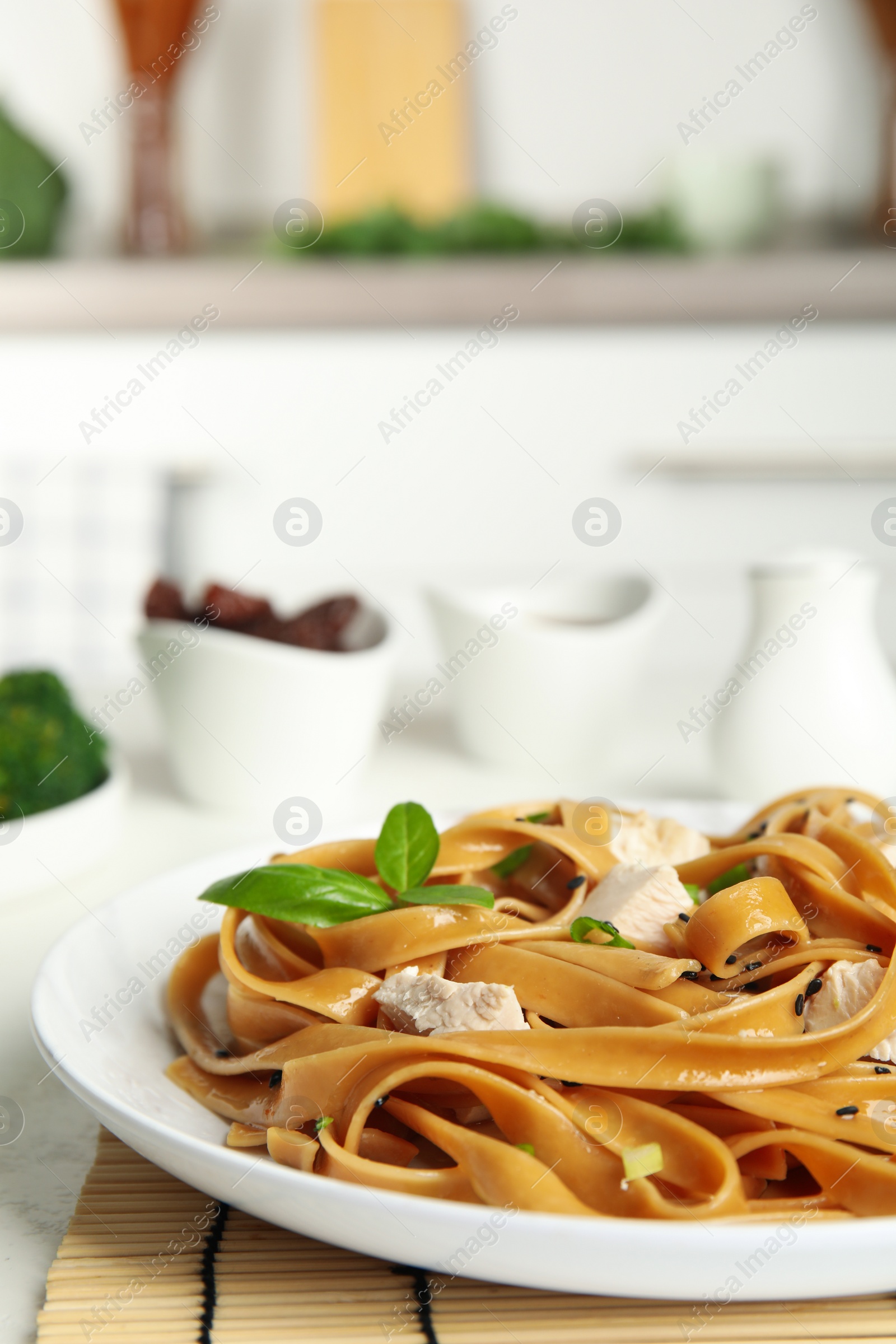 Photo of Tasty buckwheat noodles with meat served on kitchen table, closeup