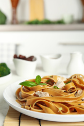 Tasty buckwheat noodles with meat served on kitchen table, closeup