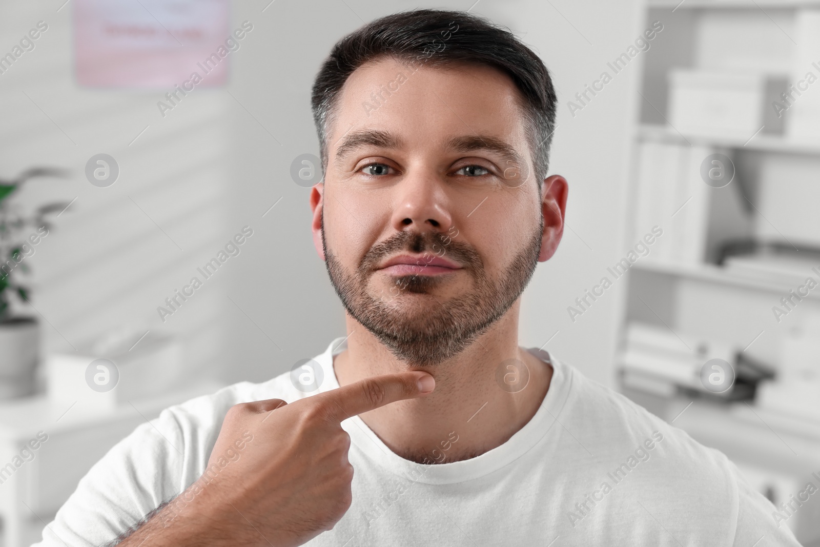 Photo of Endocrine system. Man doing thyroid self examination indoors