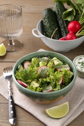 Photo of Delicious salad with radish, lettuce and dill served on wooden table