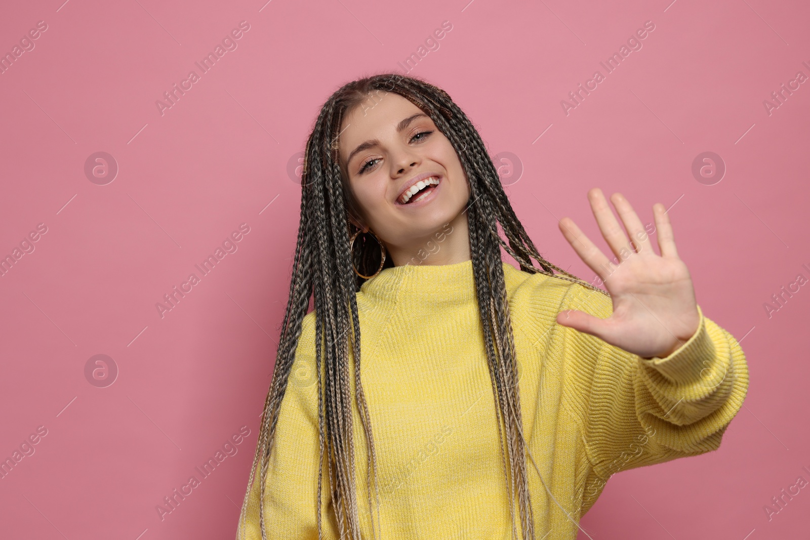 Photo of Young woman giving high five on pink background, space for text