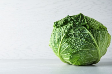 Photo of Fresh ripe savoy cabbage on light table, space for text