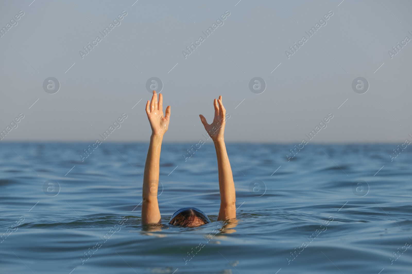 Photo of Drowning woman reaching for help in sea