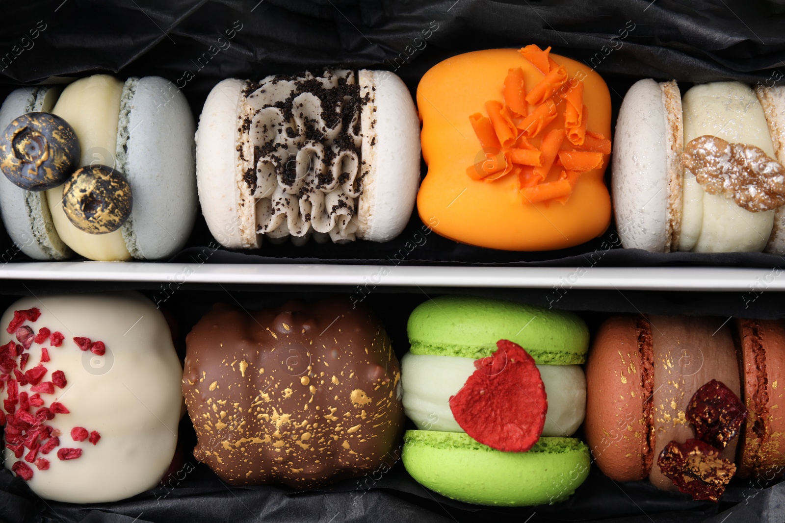 Photo of Cardboard box with delicious macarons as background, top view