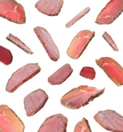 Slices of delicious dry-cured basturma falling on white background