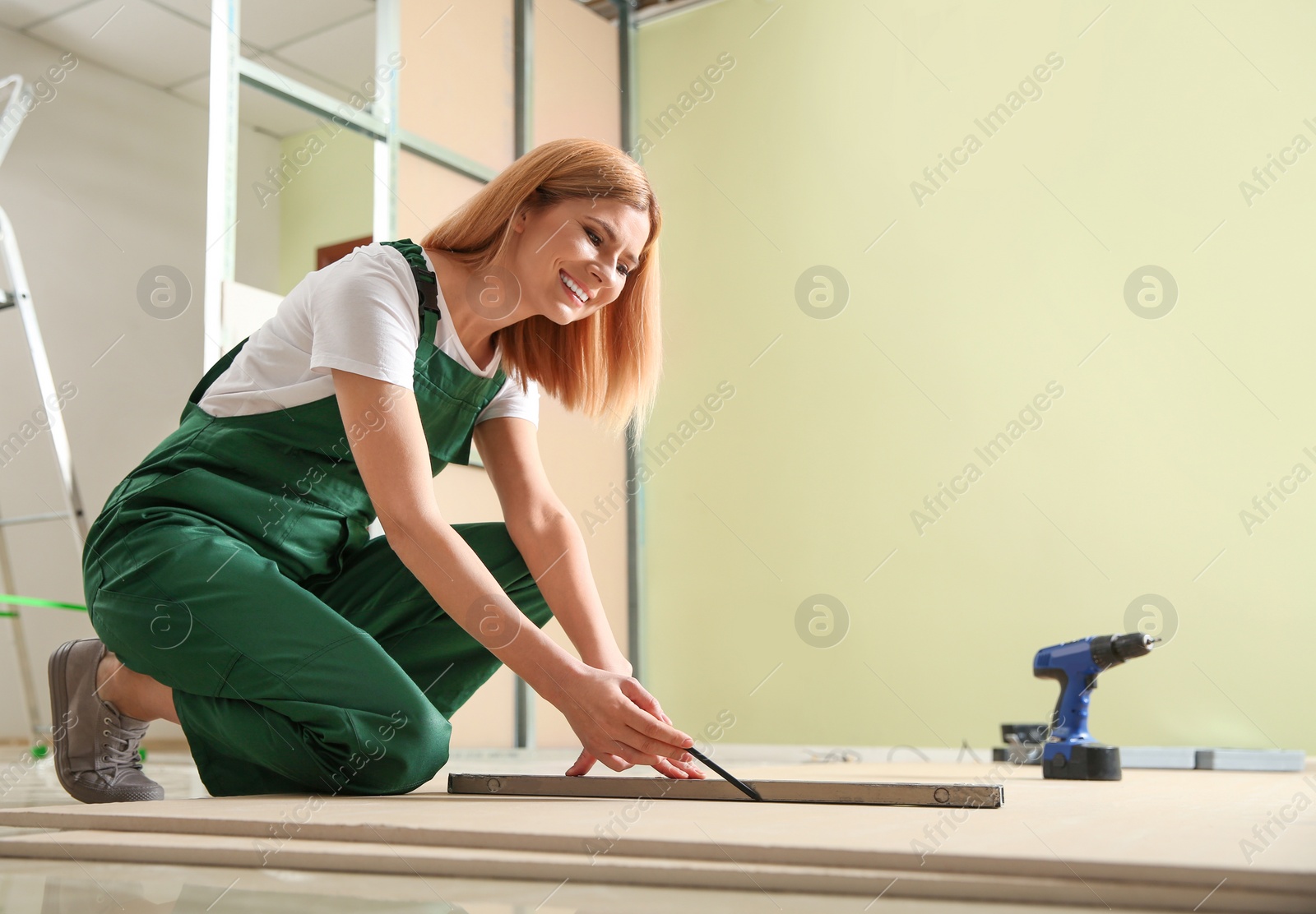 Photo of Professional builder working with drywall indoors. Home repair service