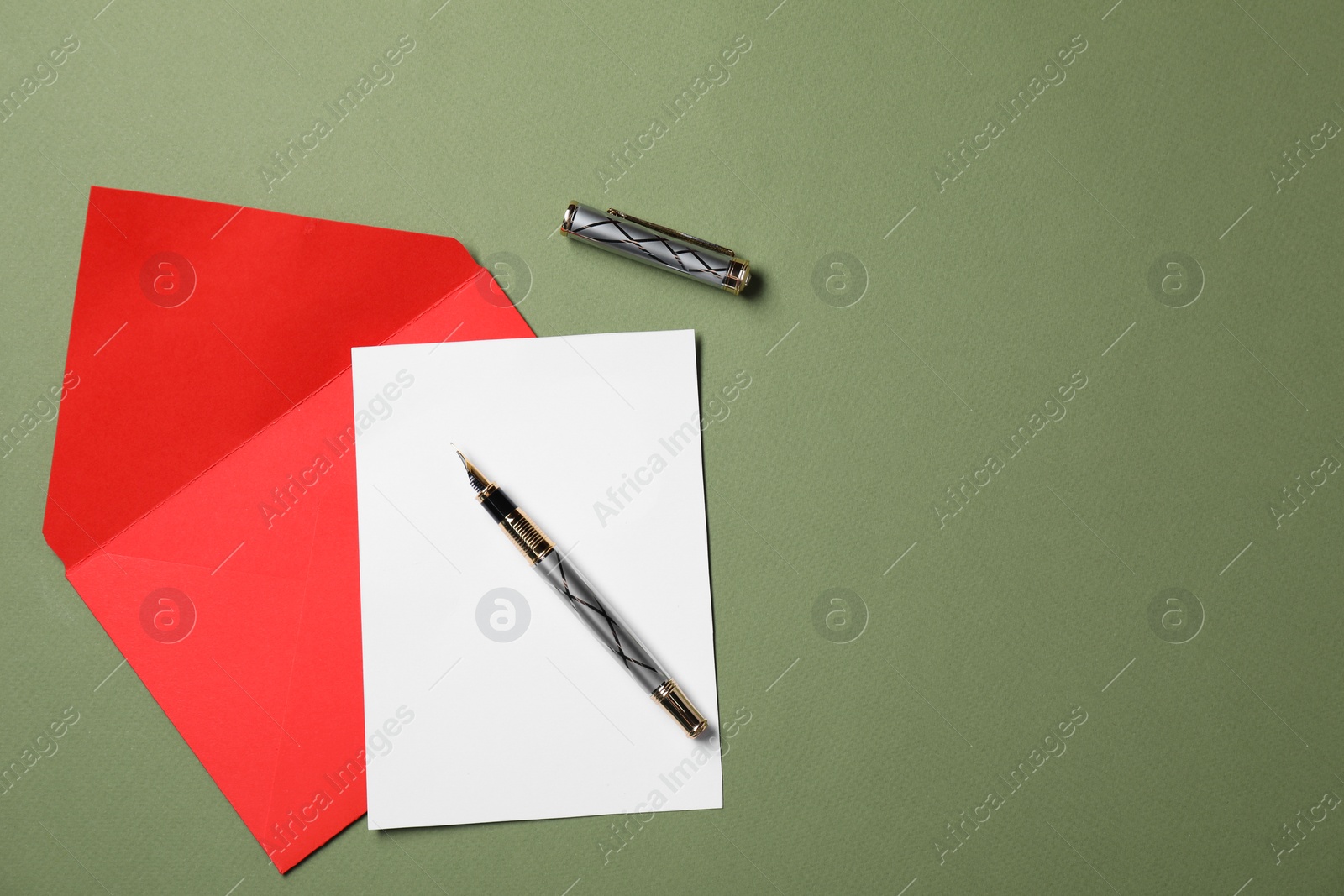 Photo of Blank sheet of paper, letter envelope and pen on green background, top view. Space for text