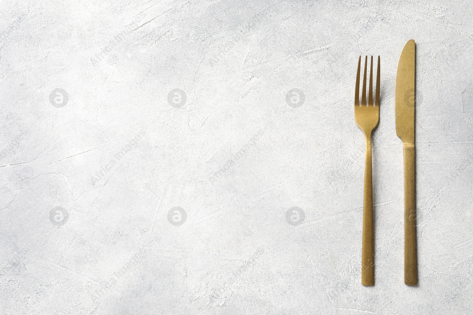 Photo of Stylish cutlery on light grey table, top view. Space for text