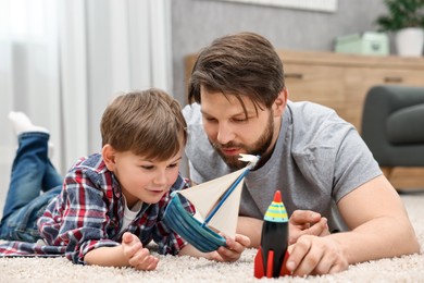 Photo of Dad and son playing toys together at home