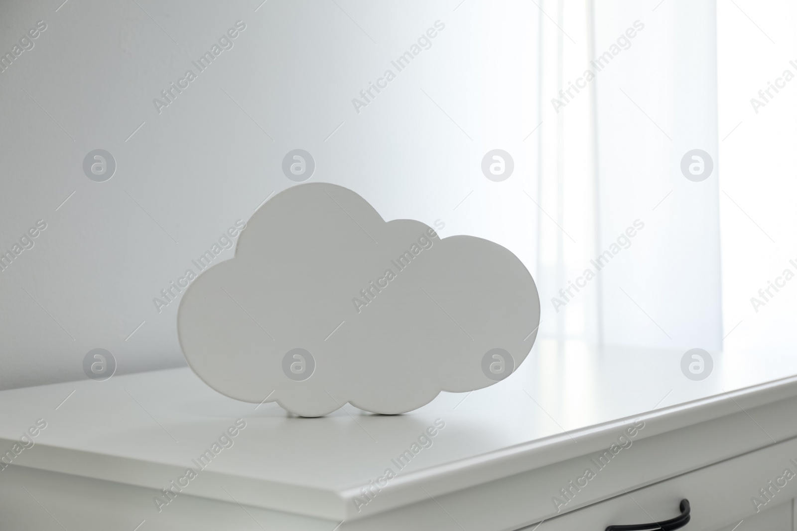 Photo of Cloud shaped night lamp on white cabinet in child's room