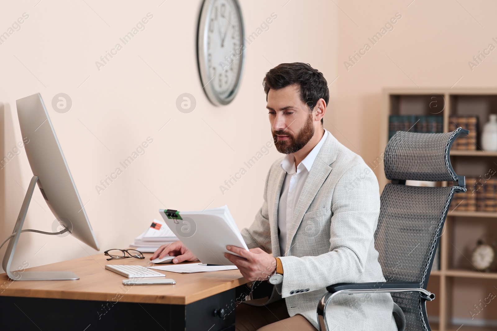 Photo of Businessman working with documents at wooden table in office