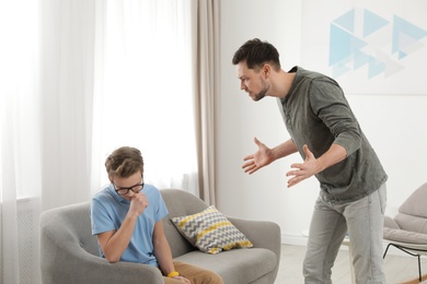 Photo of Father scolding his teenager son at home