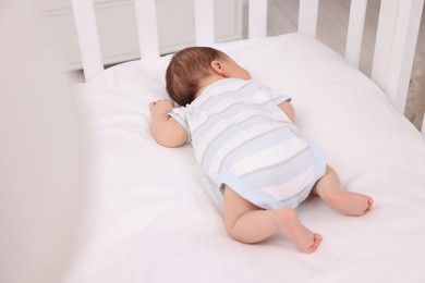Cute newborn baby sleeping in crib. Bedtime