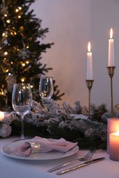 Beautiful festive place setting with Christmas decor on table indoors