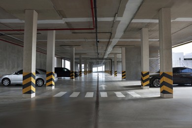 Photo of Modern cars in parking garage with pedestrian crossing