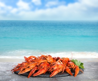 Image of Cooked crayfishes on grey table near sea