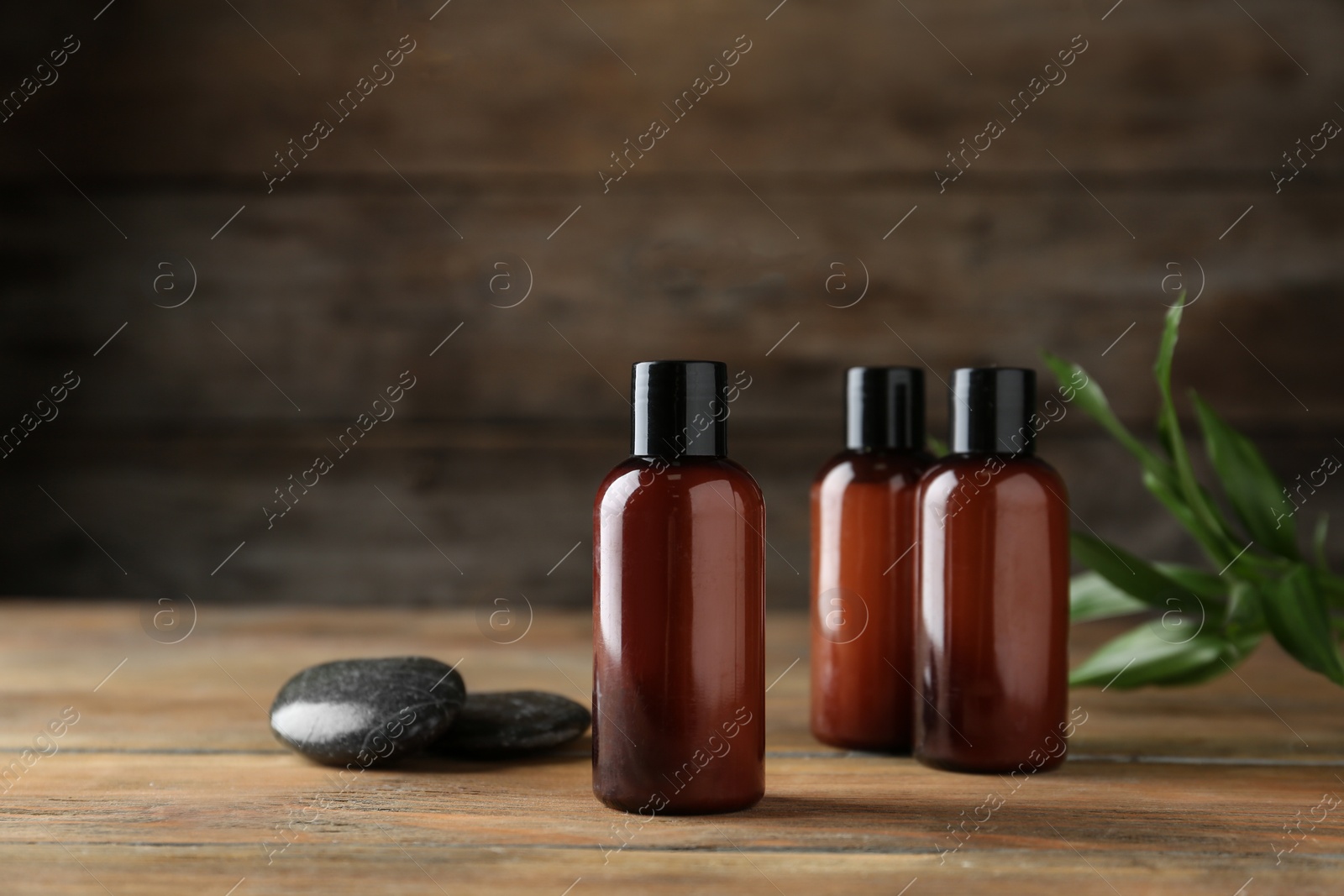 Photo of Cosmetic products and spa stones on wooden table