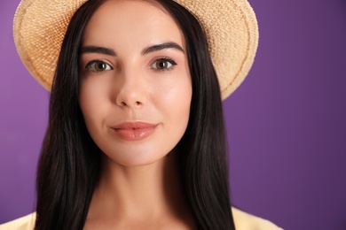 Portrait of beautiful young woman on purple background, closeup