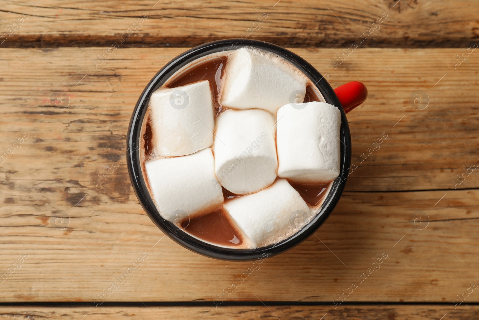 Photo of Tasty hot chocolate with marshmallows on wooden table, top view