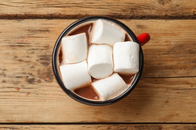Photo of Tasty hot chocolate with marshmallows on wooden table, top view