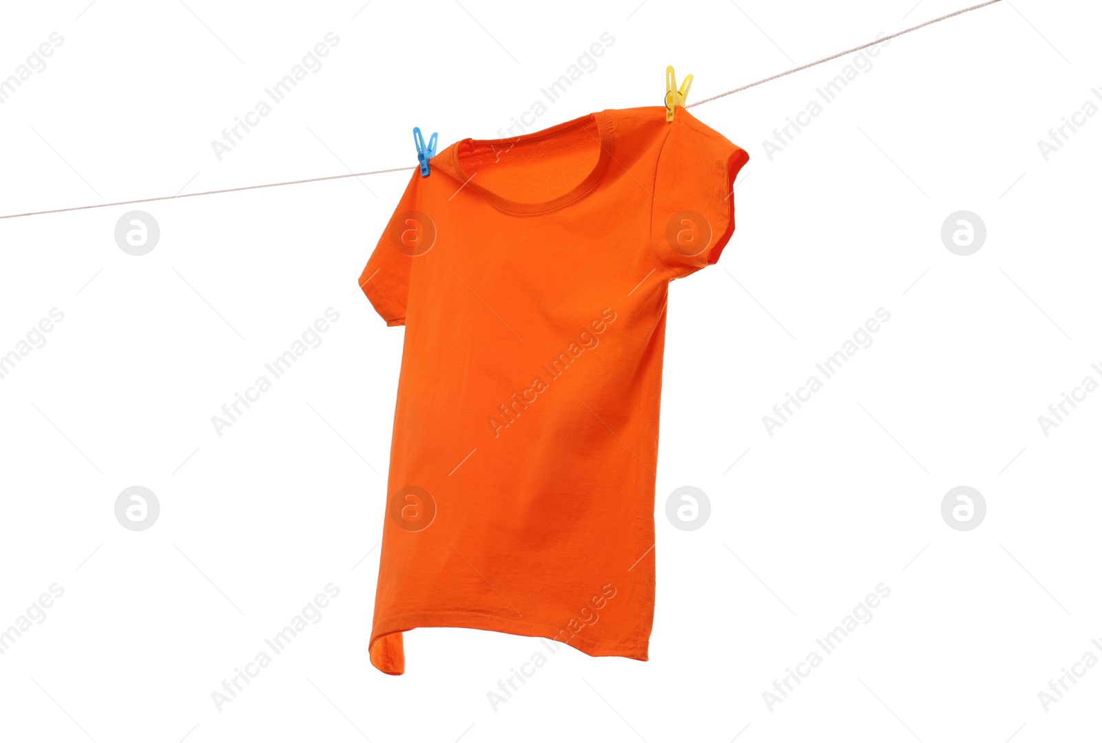 Photo of One orange t-shirt drying on washing line isolated on white