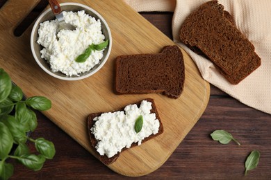 Photo of Bread with cottage cheese and basil on wooden table, flat lay