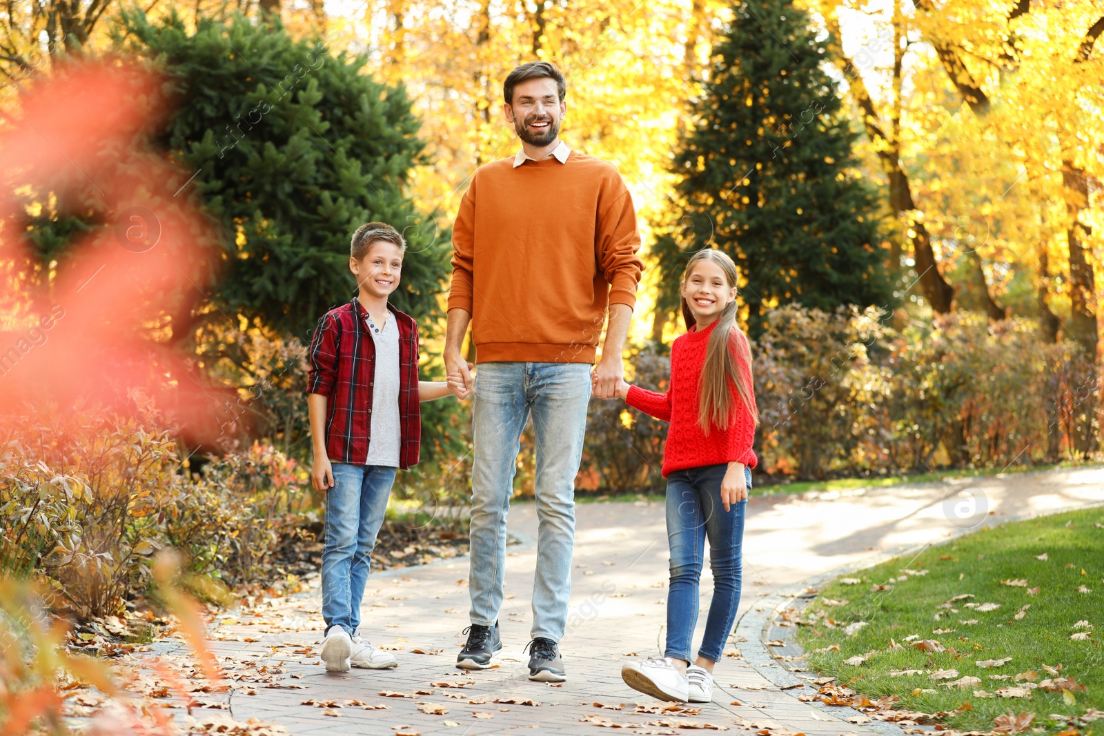 Photo of Happy father with children walking in autumn park