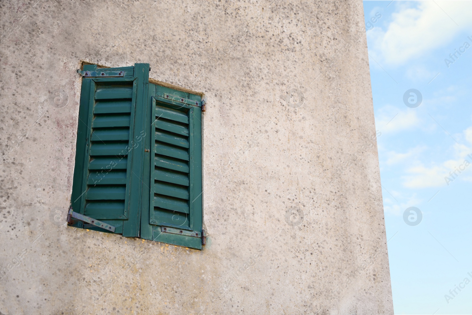 Photo of Window with old wooden shutters on concrete wall, low angle view