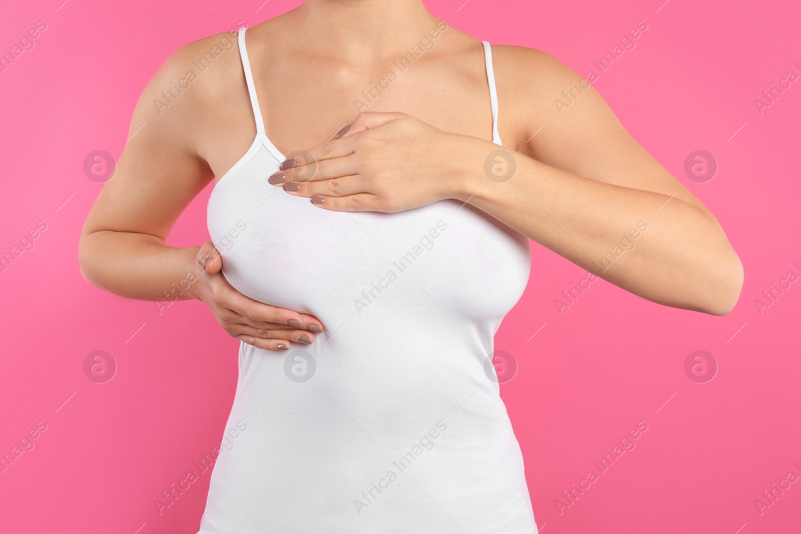 Photo of Woman checking her breast on color background, closeup