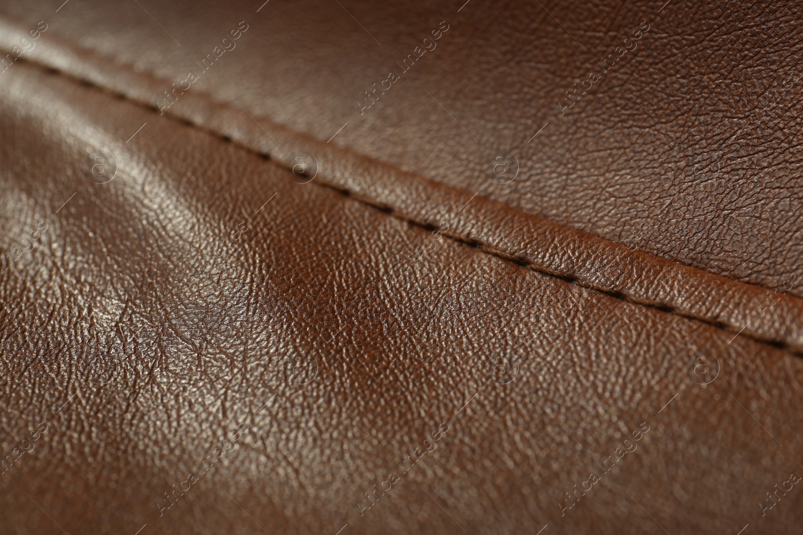 Photo of Brown leather with seam as background, closeup