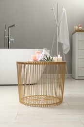 Photo of Stylish bathroom interior with ceramic tub and spa products on table