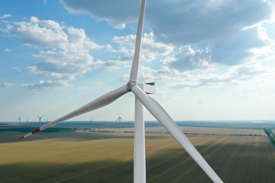 Photo of Modern windmill in wide field. Energy efficiency