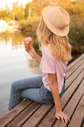 Photo of Young woman with delicious ice cream in waffle cone outdoors