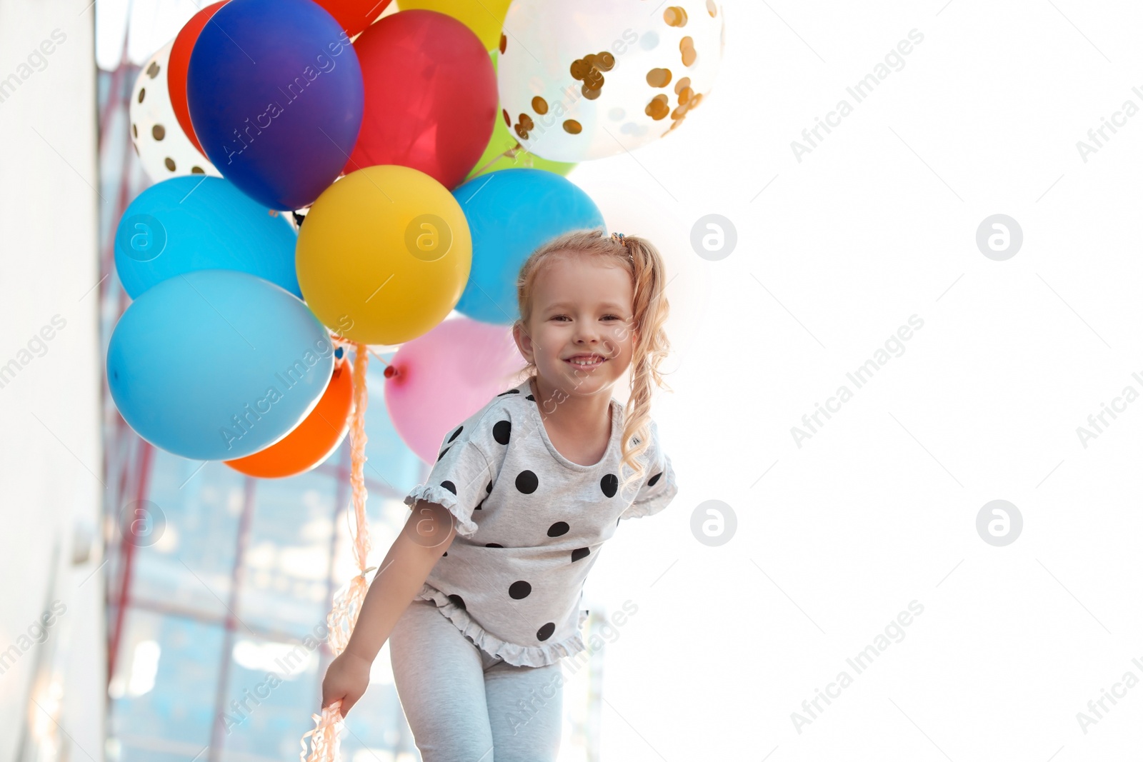 Photo of Cute little girl with colorful balloons outdoors on sunny day