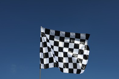 Photo of One checkered flag against blue sky outdoors, low angle view