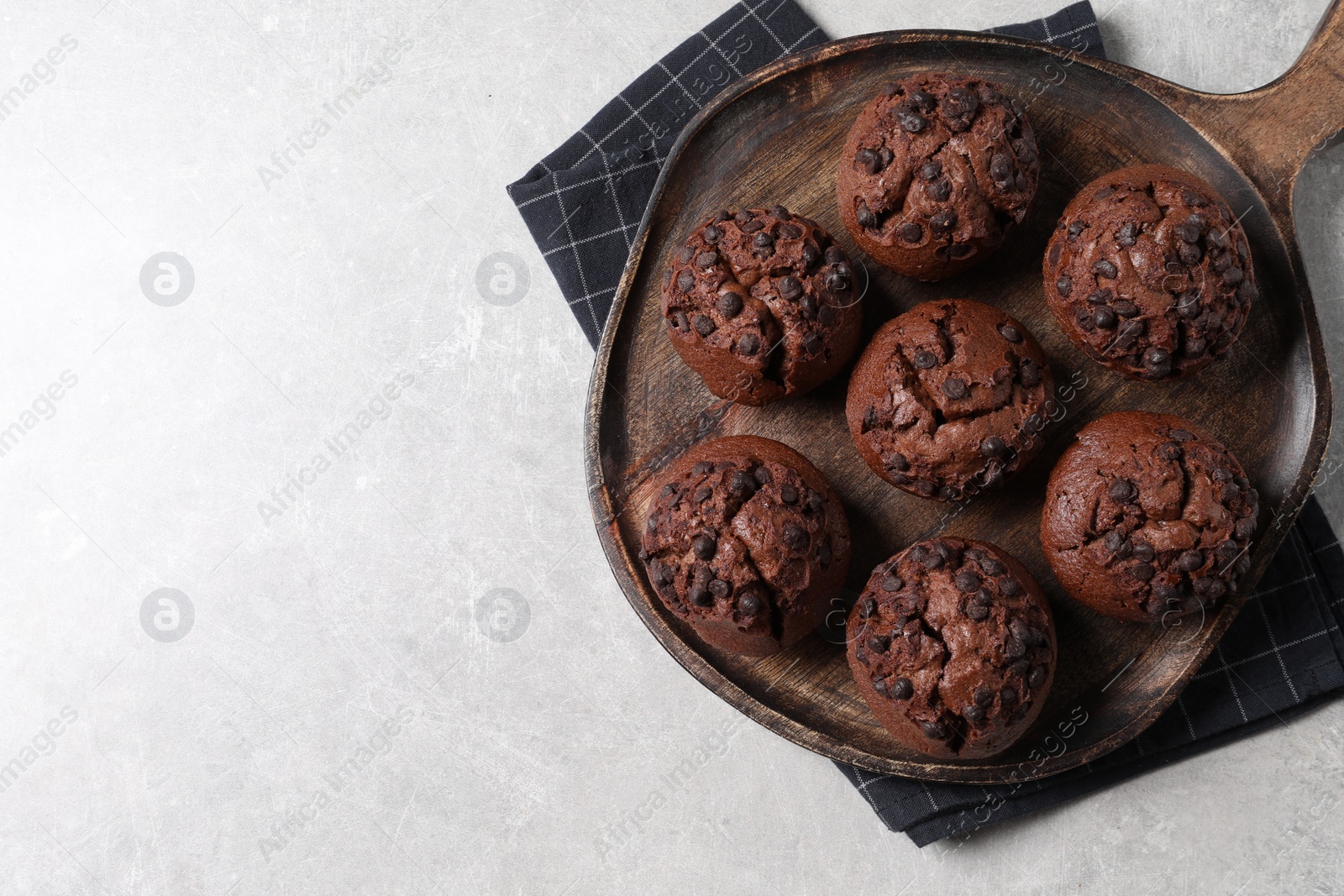 Photo of Tasty chocolate muffins on grey table, top view. Space for text