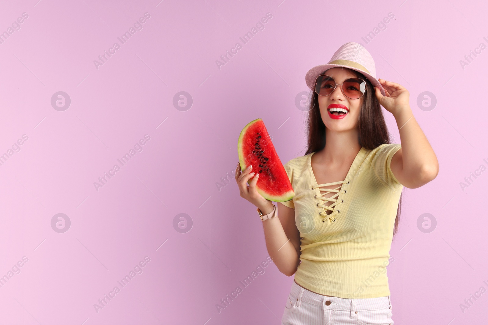 Photo of Beautiful young woman posing with watermelon on color background