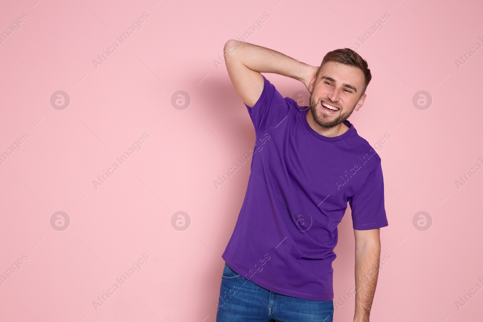 Photo of Portrait of young man laughing on color background. Space for text