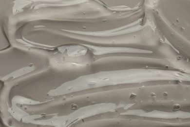 Clear cosmetic gel on grey background, top view