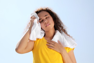 African-American woman with towel suffering from heat stroke outdoors