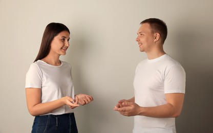 Happy young people talking on light background