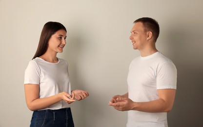 Photo of Happy young people talking on light background