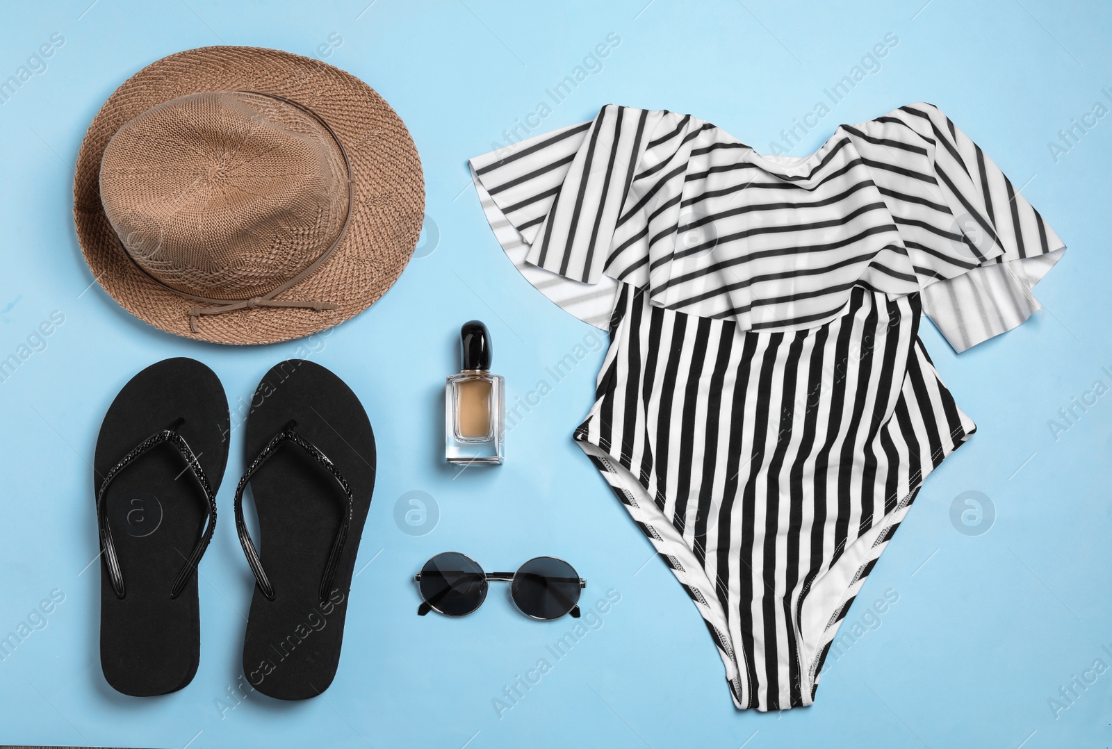 Photo of Flat lay composition with stylish beach accessories on light blue background