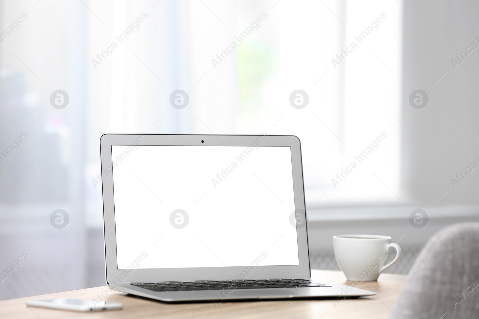 Photo of Modern laptop on desk in room. Home workplace