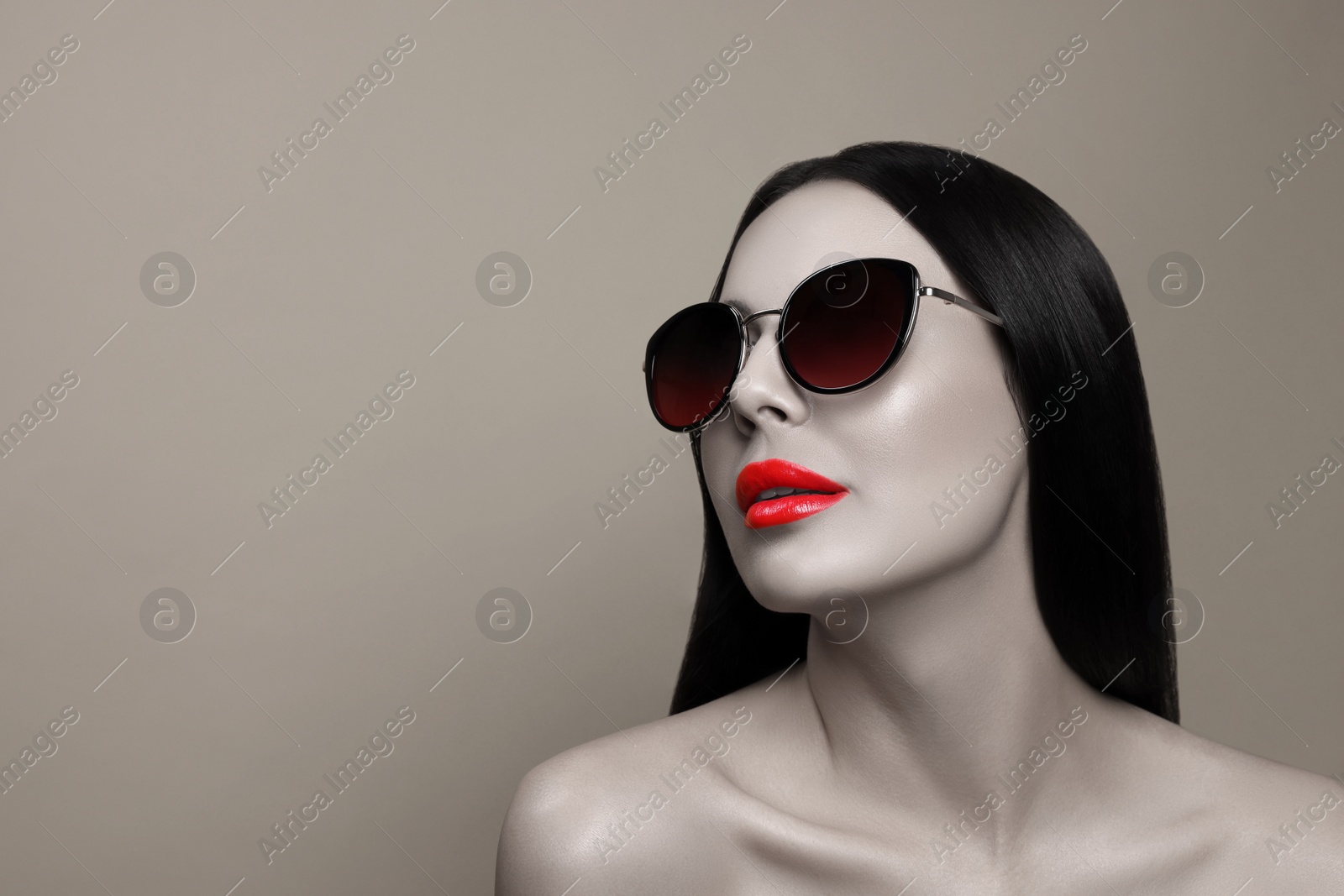 Image of Attractive woman in stylish sunglasses on beige background, space for text. Color accent