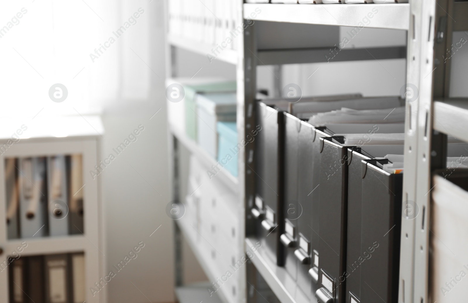 Photo of Folders with documents on shelf in archive. Space for text