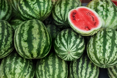 Delicious whole and cut watermelons as background