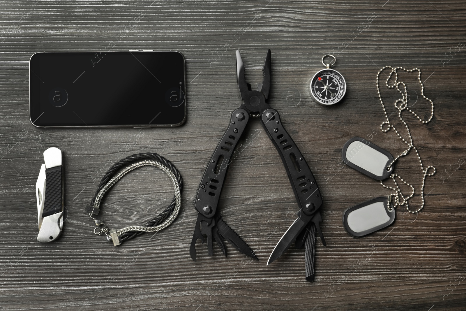 Photo of Flat lay composition with compact portable multitool and accessories on wooden table