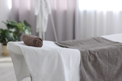 Photo of Comfortable massage table with clean towels in spa center