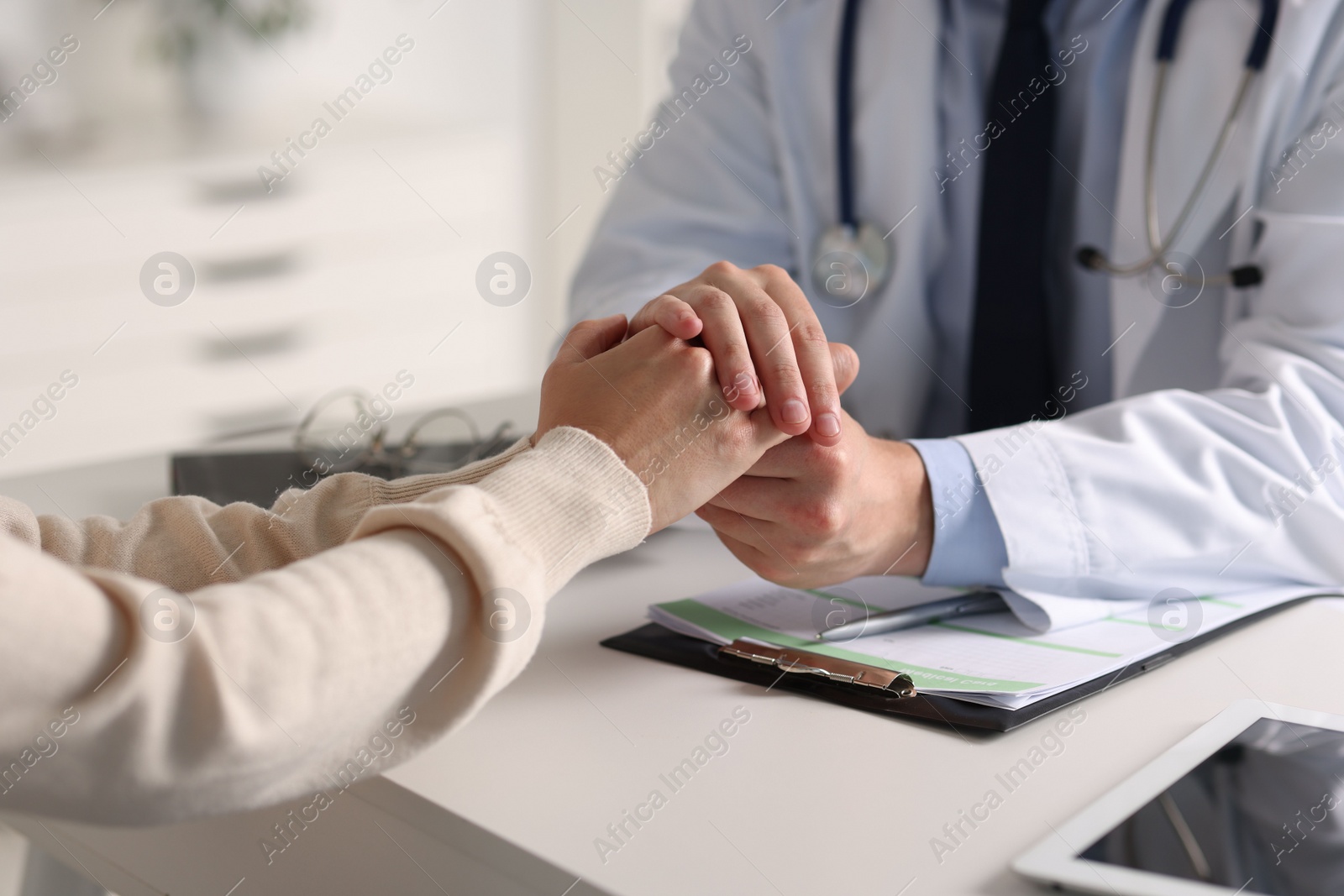 Photo of Professional doctor working with patient at white table in hospital, closeup